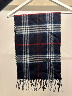 Burberry Halsduk Scarf Vintage - -Riktigt bra skick, knappt använd. Nypris på dessa ligger på runt 5000kr, vilket gör detta till ett sjukt bra pris! Halsduken är gjord i Lamull, och är perfekt inför hösten och den kommande vintern. Anledningen till att det står ”Burberry’s” och inte ”Burberry” på lappen är eftersom halsduken är från några år tillbaka, innan de bytte namn! Om du har någon fråga är det bara att skriva till mig. /elgnce