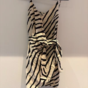 Min favorit Zebramönstrad omlottklänning - Säljer en kort zebramönstrad omlottklänning med smala axelband och knyt i midjan. Klänningen har svart och beige mönster och är perfekt för dig som vill sticka ut. Sval och lätt, passar till varma dagar. Säljer då den tyvärr blivit för liten😢