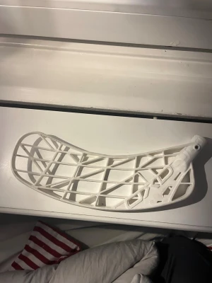 Vit innebandyblad OXDOG - Säljer ett vitt innebandyblad i plast med ett öppet rutmönster och lätt böjd form. Perfekt för dig som vill byta blad på din klubba och få bättre bollkontroll. Passar de flesta standardklubbor och är lätt att montera.