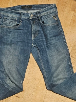 Blå Replay anbass - Snygga blå jeans från Replay. Jeansen har en något tvättad look och är tillverkade i mjukt denimtyg.Perfekta för dig som gillar en modern och stilren stil. Replay anbass