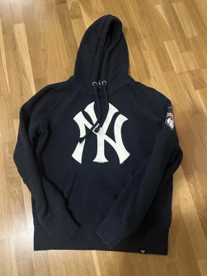 Mörkblå New York Yankees hoodie - Skön hoodie från new era, mörkblå, passar dig mellan 168-175 bäst! 