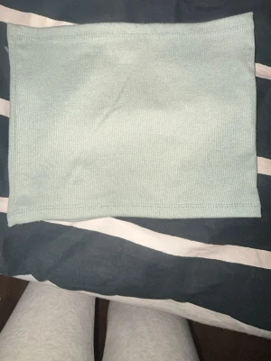 Ljusblå bandeau tubtopp - En enkel och stilren ljusblå bandeau tubtopp i ribbat material. Perfekt att matcha med höga jeans eller kjol för en trendig look. Ärmlös och utan axelband för en clean och modern vibe.