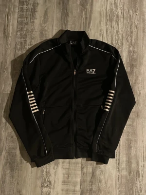 EA7 Emporio Armani Zip - Svart Zip från EA7 Emporio Armani Pris: 350kr Storlek: M Använd ett fåtal gånger! Pris kan diskuteras!
