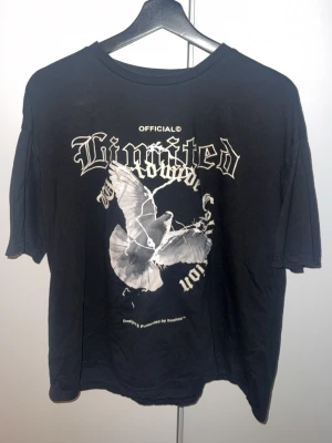 Svart t-shirt med tryck från Boohoo - Svart t-shirt från Boohoo med stort grafiskt tryck framtill. Trycket har texten 'Limited' och en duva i vitt. T-shirten har rund hals och korta ärmar, perfekt för en avslappnad streetstyle-look.