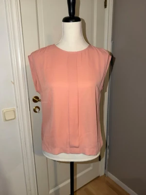 Ljusrosa topp / blus från STOCKH LM  - Säljer en ljusrosa topp från STOCKH LM i storlek 34. Toppen har en rak passform, rund halsringning och är ärmlös. Materialet känns lätt och luftigt, perfekt för varmare dagar. En enkel men snygg topp som passar till mycket.