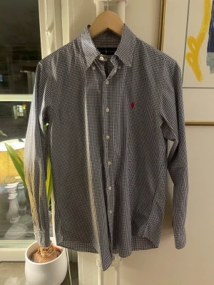 Ralph Lauren skjorta  - Tja! Säljer nu denna rutiga Ralph Lauren skjortan i storlek s! Denna vara har en liten lagning på ryggen men förutom det så är den i riktigt bra skick. Kom gärna med frågor eller bud!.