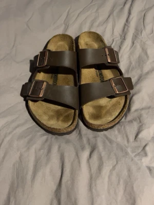 Birkenstocka Nya - Klassiska bruna sandaler från Birkenstock med två breda remmar i skinn och justerbara metallspännen. Aldrig använda, har dock varken kvitto eller låda kvar. Pris ej hugget i sten