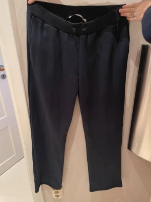 Svarta mjukisbyxor med resårmidja - Säljer ett par mörkblå mjukisbyxor med resår i midjan. Byxorna har en rak passform. 