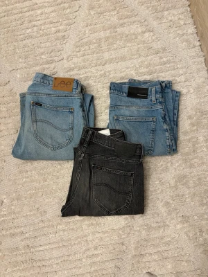 3 jeans från Lee och BLK DNM - Säljer tre par jeans: två ljusblå och ett par mörk grå. Två par är från Lee med klassisk läderpatch, de andra från BLK DNM. Alla har raka ben och klassisk femficksdesign. Lee jeansen är W30 L32 och de andra paret är W29 L32 | 600sek för alla 3
