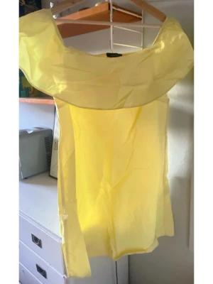 Gul axelbandslös topp med volang - jätte söt ljusgul axelbandslös klänning  med volang runt axlarna. Toppen är ärmlös och har en rak passform, jätte fin på sommaren🩷