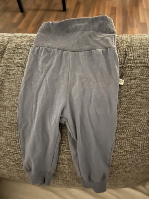 Bebis kläder Grå mjukisbyxor  - Supersköna grå mjukisbyxor från lager 157 storlek 60 cl. Byxorna har bred ribbad midja och muddar vid bensluten för extra komfort. Perfekta för små bebisar som vill ha det mjukt och bekvämt hela dagen.