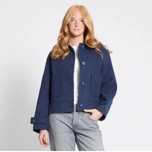 Mörkblå kappa - Säljer en stilren mörkblå kappa från lager 157. Kappan har raka linjer, stora knappar framtill och två rejäla fickor. Klassisk krage och lång ärm. Perfekt för dig som gillar minimalistisk stil.