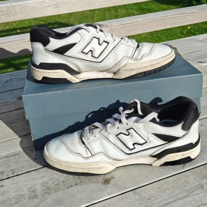 Vita New Balance 550 sneakers - Säljer ett par vita New Balance 550 sneakers med svarta detaljer och klassisk logga på sidan. Skorna är sportiga och är riktigt bekväma. Pris kan diskuteras. Kontakta vid behov av köp eller funderingar. Pris kan diskuteras.