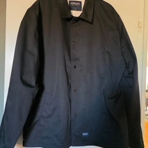 Svart jacka från Depalma Workwear XL - Säljer en svart jacka från Depalma Workwear i storlek XL. Jackan har klassisk krage, knäppning framtill och två sidofickor. Enkel och stilren design som passar till många olika outfits.