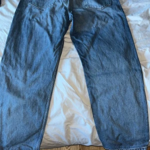 Weekday Galaxy Loose Straight Jeans 32/32 - Blå jeans från Weekday i modellen Galaxy Loose Straight. De har en rak och loose passform med klassisk femficksdesign och normal midja. Jeansen är tillverkade i bomull och har en snygg, tidlös blå tvätt.