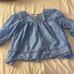 Ljusblå blus från Gina Tricot - Säljer en ljusblå blus från Gina Tricot i storlek 170. Blusen har en rund halsringning, puffiga trekvartsärmar och dekorativa sömmar nedtill. Tillverkad i mjuk bomull, perfekt för vår och sommar. Snygg och luftig modell som ger en chill vibe.