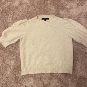 Beige stickad tröja från Vero Moda - Supermjuk beige stickad tröja från Vero Moda med puffiga korta ärmar och ribbade muddar! 💛 Tröjan har en rund halsringning och är perfekt för lager-på-lager under hösten och vintern. 🍁❄️Säljer pga att den aldrig används. Är i perfekt skit då den är nästan helt oanvänd! 💞Skulle säga att den är lite stor i storleken så den passar nog om man är storlek M! 