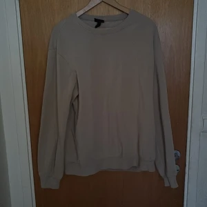 Beige sweatshirt - Enkel och stilren beige sweatshirt från H&M med rund halsringning och långa ärmar. Tröjan har en loose passform.