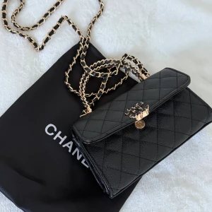 SVART MINI BAG - Svart quiltad mindre väska med handtag och axelrem. Gulddetaljer, dustbag medföljer med. Fack till korthållare finns på insidan. 