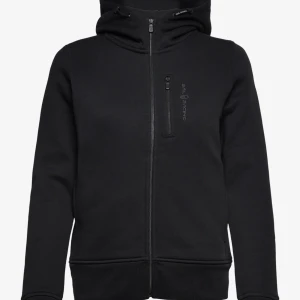 Svart hoodie från Sail Racing - Svart hoodie från Sail Racing med dragkedja framtill och en bröstficka med logga. Tröjan har huva, långa ärmar och är tillverkad i ett mjukt material som passar perfekt till kyliga dagar. Snygg och enkel design med diskreta detaljer.