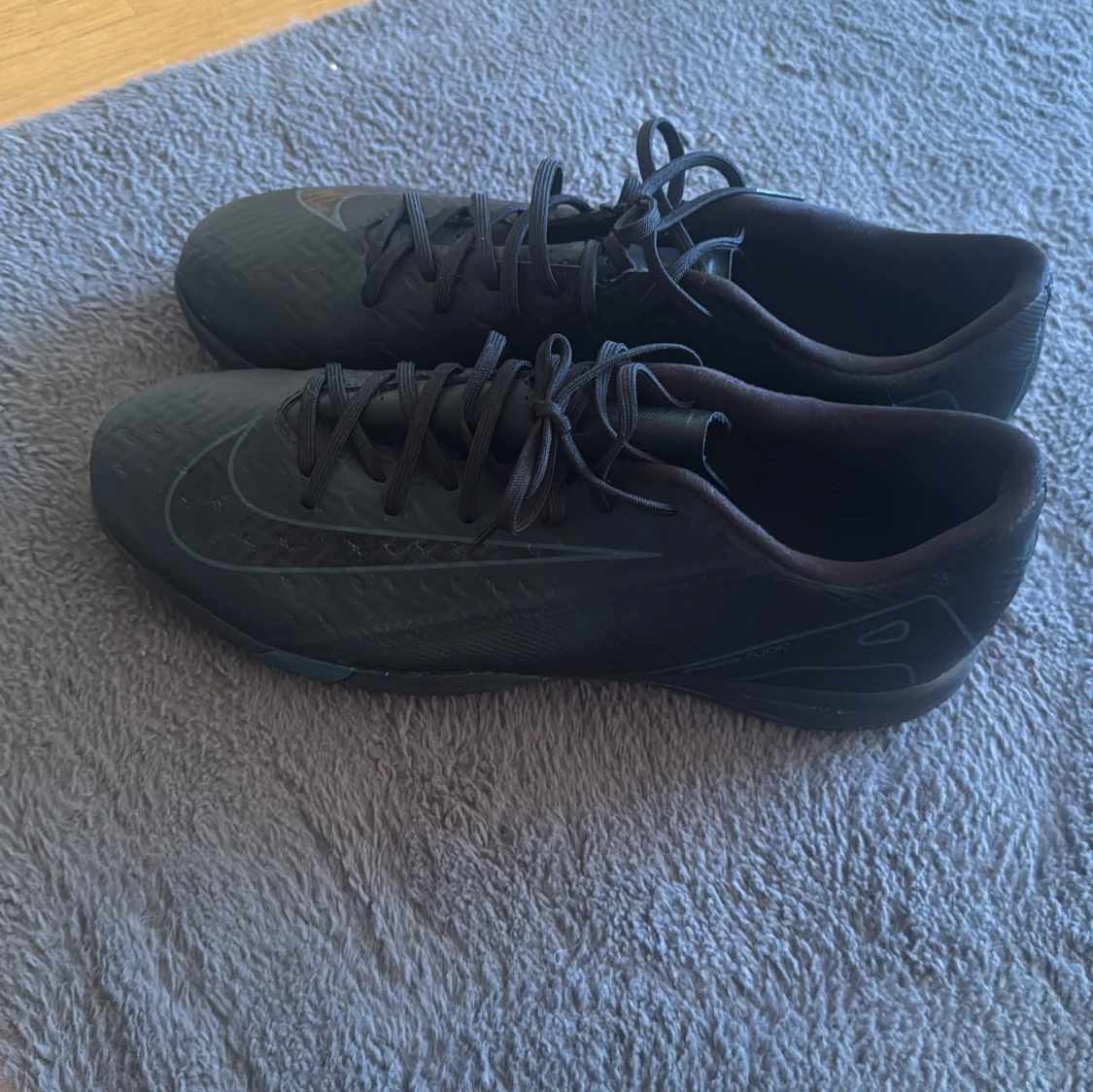 Svarta Nike fotbollsskor med snörning