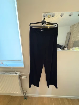 Svarta vida byxor från BikBok M - Svarta byxor från BikBok i storlek M. De har en rak och vid passform med hög midja och är tillverkade i ett mjukt, lätt material som faller snyggt. Perfekta för en chill och stilren look.