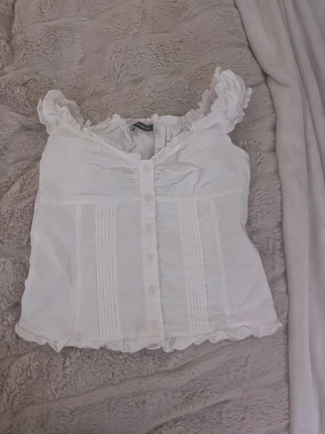 Vit blus med volang och knappar