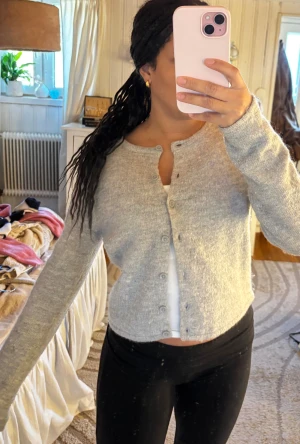 Grå kofta med knappar - Mysig kofta från Gina. Säljer pga att jag aldrig använder den längre! Lite knottrig men annars superbra skick! 