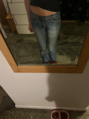 Blå bootcut jeans från Acate - Snygga ljusblå bootcut jeans från Acate med låg midja och stretch. Jeansen har klassisk femficksdesign. Fina slitningar på jeansen som är en design