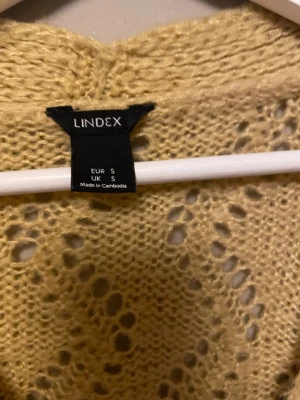 Gul stickad kofta från Lindex - Säljer en ljusgul stickad kofta från Lindex i storlek S. Aldrig använd.