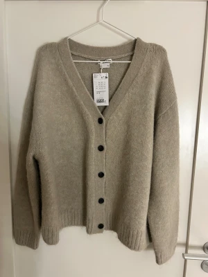 Beige kofta helt ny med prislapp från weekday - Säljer denna kofta från weekday aldrig använd med prislapp kvar strl M, säljes då den aldrig kommit till användning❤️ Nypris 570kr