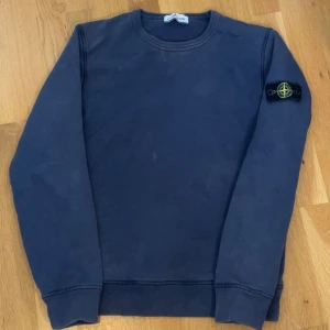 Mörkblå sweatshirt från Stone Island - Säljer en mörkblå sweatshirt från Stone Island. Är storsta storleken på junior. Passar xs och folk runt 170. Har en liten fläck där fram på tröjan men syns knappt. Krymper i tvätten så den är lite mindre än xs. Är 167 och den sitter i midjan. Är mindre men funkar som vanligt
