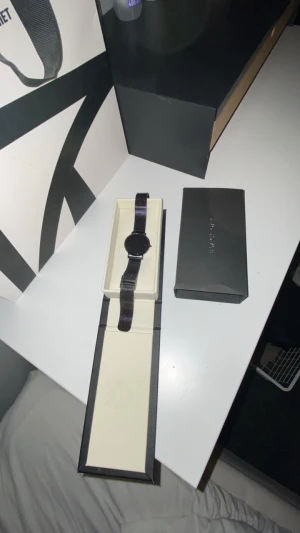 Svart klocka från Black Oak - Stilren svart klocka från Black Oak med mesharmband i metall och minimalistisk rund urtavla. Kommer i originalförpackning med elegant svart box. Perfekt accessoar för dig som gillar en clean och modern look.