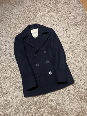 Ralph lauren Denim and supply peacoat rock ull kashmir svart l - Ralph Lauren Denim and Supply peacoat i svart elegant ull. Mycket väl omhändertagen i nytt skick förutom en liten defekt på insidan som inte märks alls. Svårt o få tag på speciellt i detta skick. Storlek S men sitter mer som M. Postas antigen samma dag som köp eller dagen därpå🙌💯