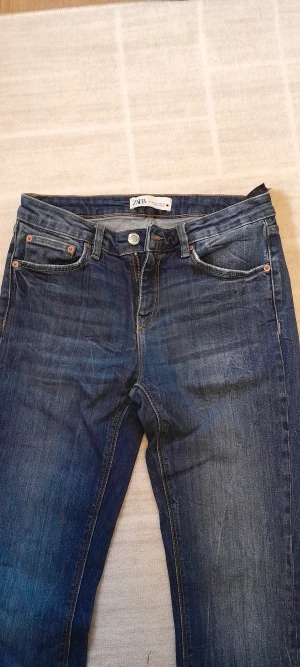 Mörkblå jeans från Zara, strl 40 - Säljer ett par mörkblå jeans från Zara i klassisk femficksmodell. Jeansen har normal passform, dragkedja och knapp framtill samt slitna, fransiga benslut för en avslappnad vibe. Tillverkade i tåligt denimtyg som sitter snyggt hela dagen.   Skriv för frågor eller fler bilder!💕   !Endast swish!!