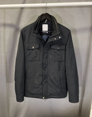 J Lindeberg field jacket fodrad - Otroligt snygg field jacka från j Lindeberg! Den är fodrad så passar helt perfekt för vinterjacka! Den har dessutom fodrade fickor med dragkedja! LAGAD PÅ 2 STÄLLEN! Fråga om bild om du vill se lagningarna! Size M. Modellen är 179cm och den passar men är något stor. Perfekt för ca 180-185cm! Hör av dig vid minsta fundering 🤩