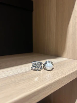 Edblad ringar - Två coola silverringar, en med ett geometriskt mönster av små pyramidformer och en med en stor vit pärla infattad i blankt silver. Perfekt för dig som gillar statement-smycken och vill sticka ut med din stil. Man får gärna köpa en av ringarna! 