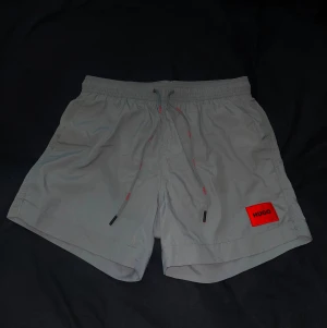 Hugo Boss badbyxor - Hugo Boss grå badbyxor i storlek M. Använda en enda gång.  Modell: Dominica