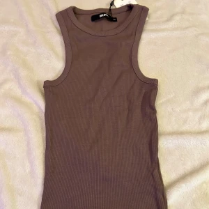 Brun topp  - Säljer ett helt nytt brunt linne från BikBok i storlek XS. Aldrig använd och prislappen sitter kvar. Väldigt fin och sitter snyggt på.🩷