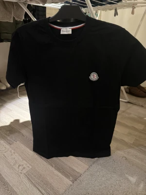 Svart Moncler t-shirt med logga - Svart fin moncler tshirt. Köpt på outlet i spanien för 110€. Storlek s och bra skick. Hör av er vid frågor eller liknande! Pris kan såklart diskuteras!!