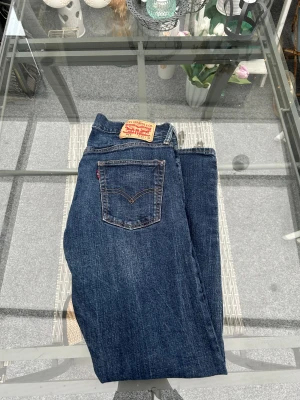 Levi’s 514 Straight Fit Jeans – W34 L30, mörkblå denim - Levi’s 514 Straight Fit Jeans i mörkblå denim – storlek W34 L30 – klassisk rak passform, autentisk red tab, original patch, hög kvalitet, tidlös modell, bekväm midja, snygg tvätt, perfekt vardagsjeans, slitstarka och ikoniska Levi’s-denim med naturligt slitage och riktigt bra begagnat skick