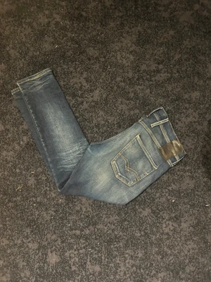 Replay Jeans Anbass 31/30 - Tja, säljer dessa Replay anbass jeans i storlek 31/30 då de är för små för mig. De är i bra skick och väldigt sköna byxor med bra stretch. Dock en slitning som syns på sista bilden där av priset. Inget rejält direkt som gör att fixa lätt men något jag ej tar tag i då de är för små. Hör av dig vid frågor! 