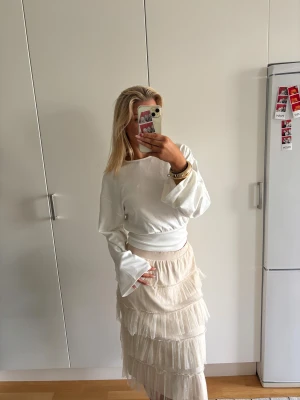 Beige volangkjol med mesh - Supersöt beige långkjol med flera lager volanger i mesh. Kjolen har en elastisk midja och ett skirt! Älskar älskar denna kjolen