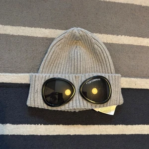 Grå ribbad goggelsmössa C.P. Company - Grå cp company mössa nästan helt ny använd 4-6 gånger kanske tveka inte på att skriva frågor priset är inte hugget i sten.