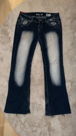  Crazy Age jeans - Säljer ett par blå bootcut jeans från Crazy Age. Jättebra skick förutom en sminkfläck (syns på första bilden) och slitningar på benen. Priset går att diskutera!!💕 Ytterbenslängd- 92cm             Innerbenslängd- 70 cm   Midja- 39 cm