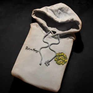 Rick and Morty Portal Boyz hoodie - Snygg ljusgrå hoodie med Rick and Morty-tryck fram och stort Portal Boyz-motiv på ryggen. Tröjan har huva med snörning, känguruficka och långa ärmar. Perfekt för dig som älskar serien och vill sticka ut med cool grafik.