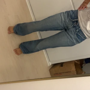 Blå bootcut jeans från Only, 36/32 - Snygga ljusblå bootcut jeans från Only med klassisk femficksdesign och coola detaljer på bakfickorna. Jeansen har normal passform och är tillverkade i mjuk bomull med lite stretch för extra komfort. Perfekt för dig som gillar avslappnad stil. vintage