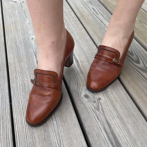 Italienska vintage läderklackar - Supersöta italienska bruna vintageklackar i loafersmodell med en 4cm klack. Klacken är av trä och skon av läder. Väldigt bra skick. Märket är Cherry Boutique. Storlek 38, liten storlek. Jag skulle säga att de är mer som en 37a. 