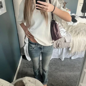  Jeans  - Säljer ett par blå jeans från Bershka i storlek 34. De har låg midja, klassisk femficksdesign och raka ben med lätt bootcut. Jeansen är tillverkade i denim med snygga slitningar. 34cm⬅️➡️💗