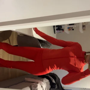 Röd träningshoodie med dragkedja och byxor  - Säljer detta set aldrig använt då de inte kommer till användning skit snyggt helt nytt vet inte märket på de då ja köpte utomlands men bra material, matrialet är lagom tjockt så man inte ser igenom är 161 och byxorna sitter perfekt i längden!